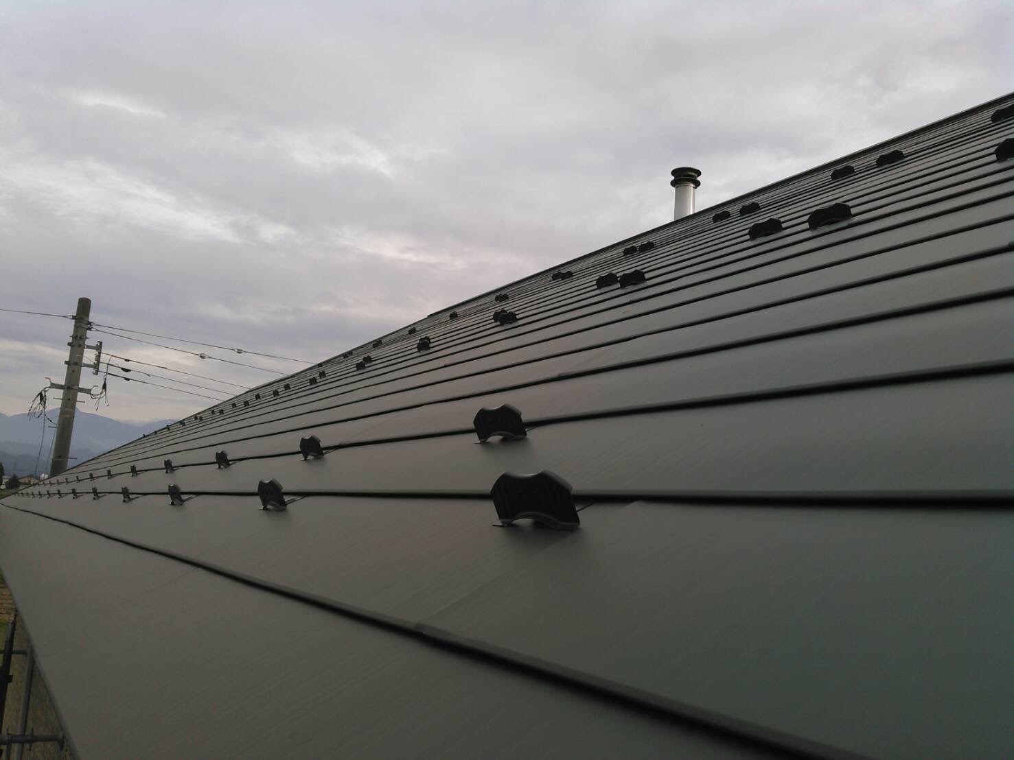 ニチハの金属製屋根材「超高耐久 横暖ルーフ」にて屋根カバー工事を行いました。